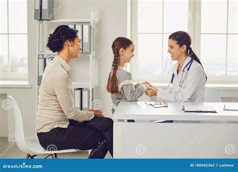Woman Pediatrician Doctor Talking With Mom And Baby At Clinic Office