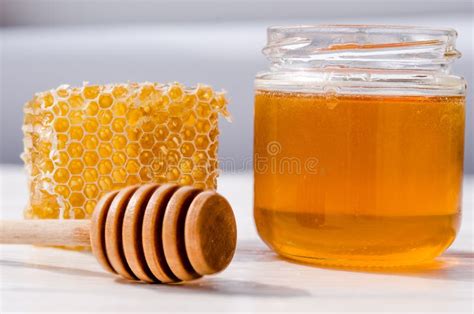 Honey Dripping From A Wooden Spoon Onto Honey Comb Stock Photo Image