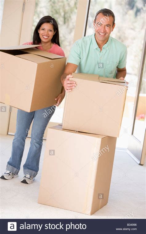 Couple With Boxes Moving Into New Home Smiling Stock Photo Alamy