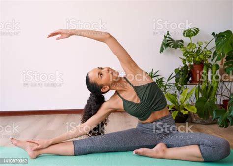 A Young Multiethnic Woman Reaches Overhead In Seated Side Stretch Yoga