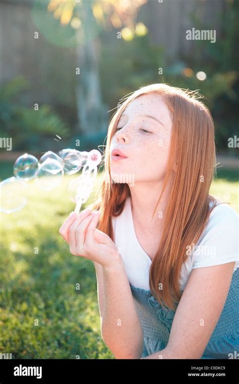 Girl Blowing Bubbles Outside Stock Photo Alamy