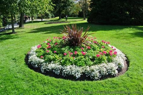 Circular Mini Garden With White Red Flowers And Dark Grass In The
