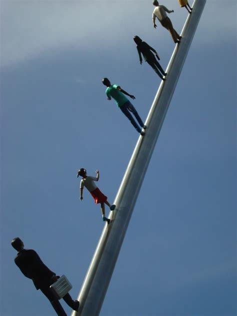 Gravity Defying Sculpture Of People Walking Up A Pole