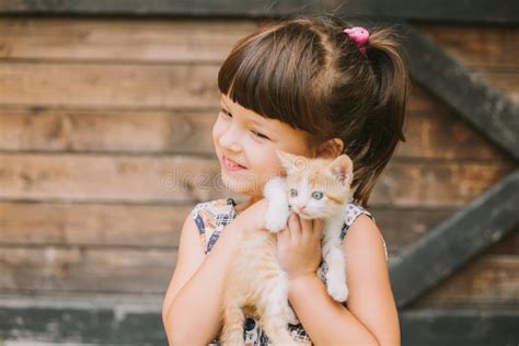 Cheerful Little Girl Holding A Cat In Her Arms Stock Photo Image Of