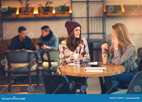 Two Friends Enjoying Coffee Together In A Coffee Shop Stock Image