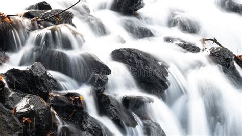 White Rushing Water Flowing Over Exposed Jagged Rocks Stock Image