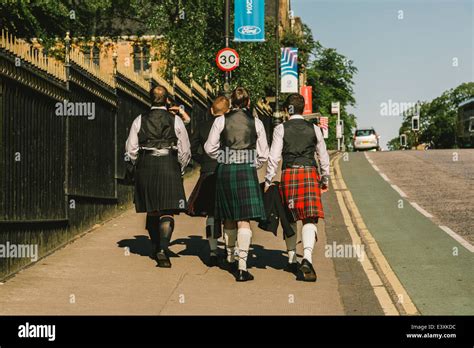 A Group Of Young Scottish Students Wearing Kilt Dress Walking To