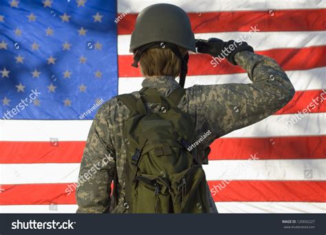 Rear View Of A Female Soldier Saluting American Flag Stock Photo