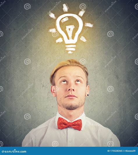 Man With Thoughtful Expression And Bright Light Bulb Over His Head