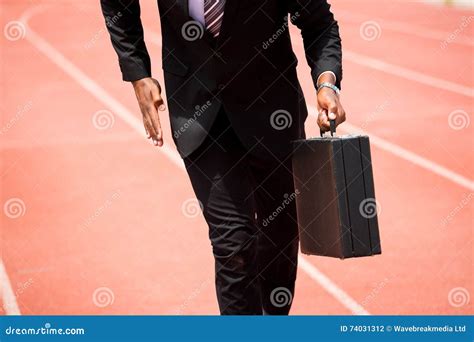 Mid Section Of Businessman Running On A Running Track Stock Photo