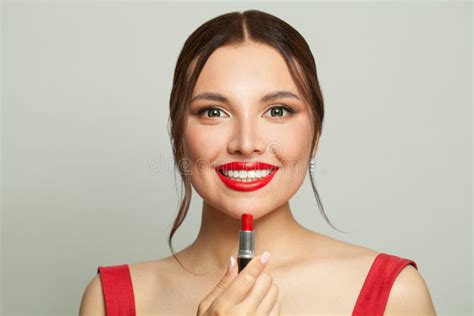 Beautiful Young Woman Holding Red Lipstick Near Lips On White
