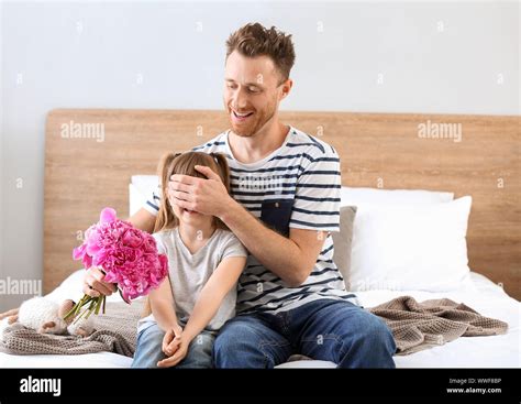 Father Giving Bouquet Of Flowers To His Little Daughter At Home Stock
