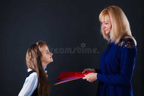 The Teacher Gives The Girl Student Folders With Teaching Material Stock
