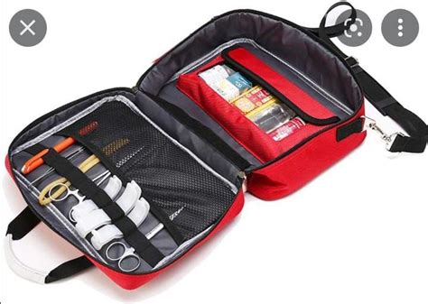 An Open Red And Black Bag With Tools In It On A White Surface Next To