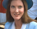 a woman wearing a blue hat smiles for the camera