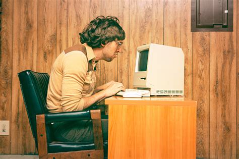 Funny Nerdy Man Looking Intensely At Vintage Computer Stock Photo