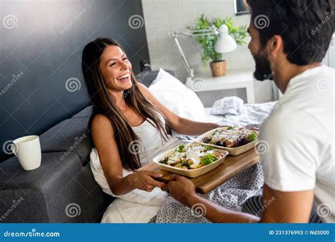 Hombre Feliz Que Trae El Desayuno A Su Novia En La Cama Imagen De