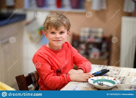 Cute Little Kid Boy Watching Tv In The Evening Before Going To Bed