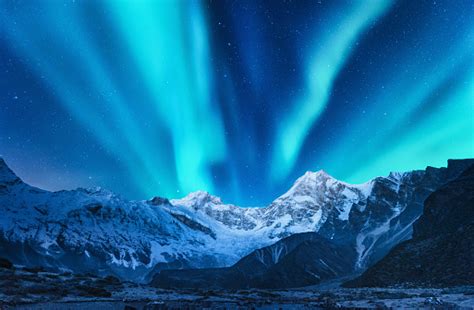 Aurora Borealis Above The Snow Covered Mountain Range In Europe