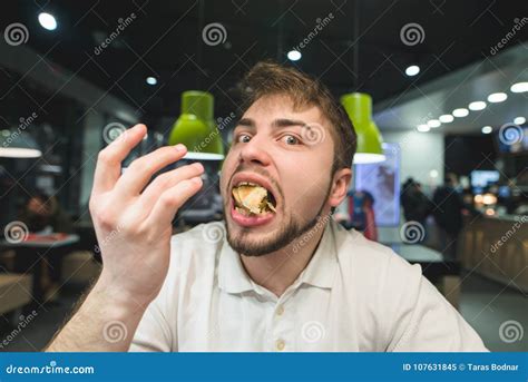 a funny man with a mouth full of food looks at the camera the hungry man got a full mouth of