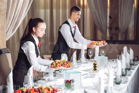 Waiters Serving Table In The Restaurant Preparing To Receive Guests