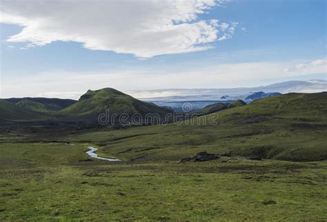 icelandic landscape with tindfjallajokull glacier green hills river stream and lush grass and