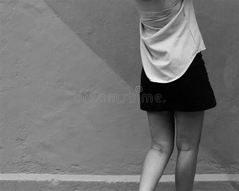 Black And White Of Woman S Legs In A Short Black Skirt In Front Of A
