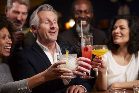 Group Of Middle Aged Friends Celebrating In Bar Together Stock Image