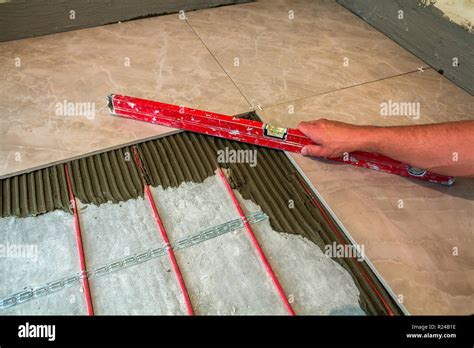 Ceramic Tiles And Tools For Tiler Worker Hand Installing Floor Tiles