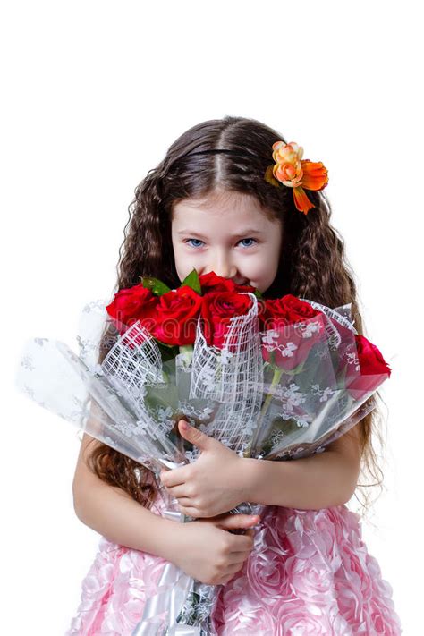 Beautiful Little Girl In A Pink Dress With A Bouquet Of Red Roses Stock