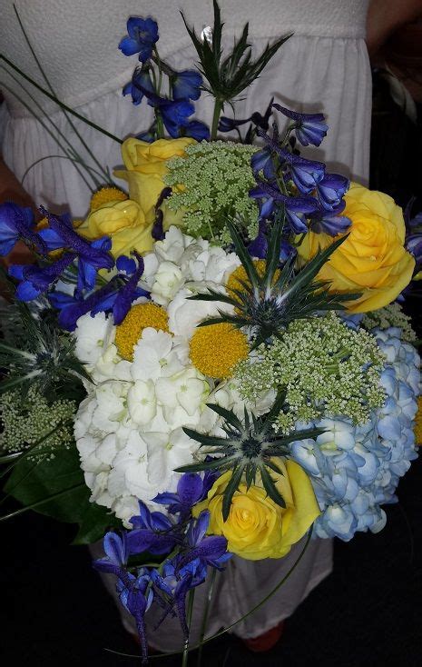 A Fun Garden Bouquet Of Yellow Roses Craspedia Blue Delphinium