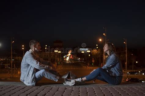 Guy And Girl Are Sitting Opposite Each Other On Evening City Background