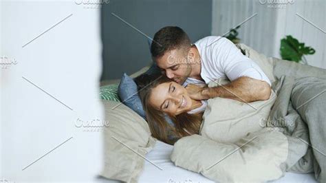 Young Beautiful And Loving Couple Wake Up At The Morning Attractive Man Kiss And Hug His Wife