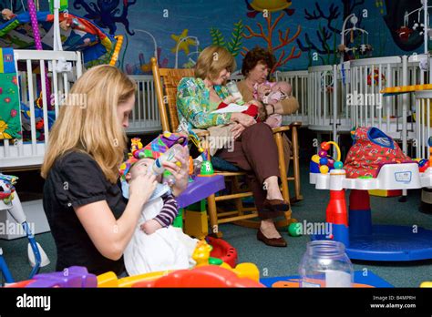 Daycare Workers Feeding Infants In Nursery Stock Photo Alamy