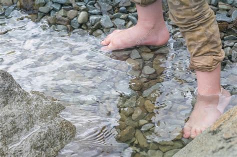 Premium Photo The Bare Feet Of A Boy In The Water On The Rocks