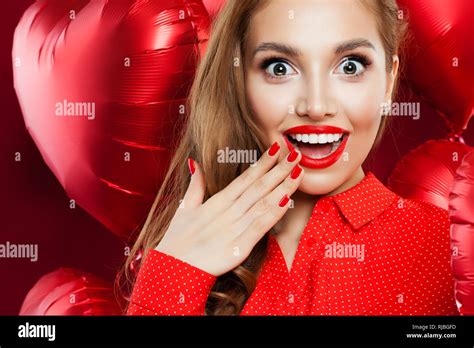 Surprised Woman With Red Lips Makeup And Manicured Hand On Red Heart Balloons Background