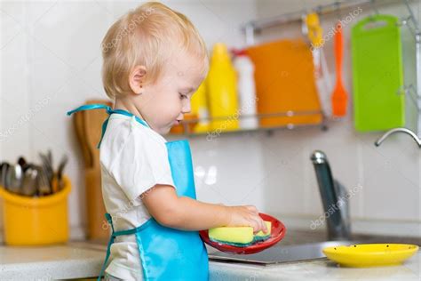 Child Washing Dishes In A Domestic Kitchen — Stock Photo © Oksun70