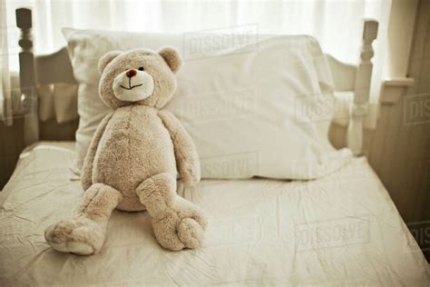 Teddy Bear Sitting On A Childs Bed Stock Photo Dissolve