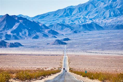 View Of Long Endless Road Going Up Into Desert Mountains Stock Photo