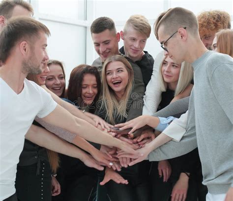 Large Group Of Young People Joining Their Hands Together Stock Photo