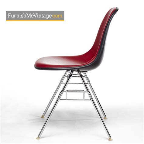 The chair is upholstered in green vinyl and has an aluminum base. Eames by Herman Miller Vinyl Red Fiberglass Shell Chairs