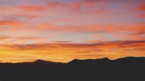 Download Wallpaper 1366x768 Sunset Mountains Horizon Clouds Tablet