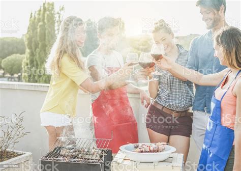 바베 큐 파티젊은 이들이 도시 전망 배경에서 야외 바베 큐 저녁 식사를 하 고지붕 위에 레드 와인으로 응원 하는 행복 한 친구