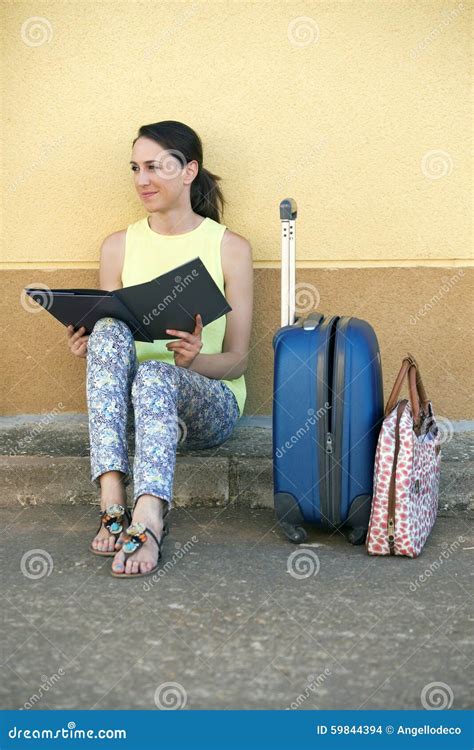 Young Woman Tourist Sitting With Luggage And A Travel Brochure I Stock