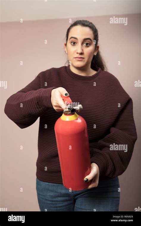 Young Woman Pointing A Fire Extinguisher Forwards Stock Photo Alamy