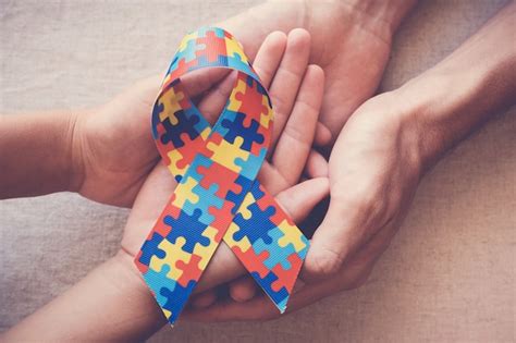 Hands Holding Puzzle Ribbon For Autism Awareness Premium Photo