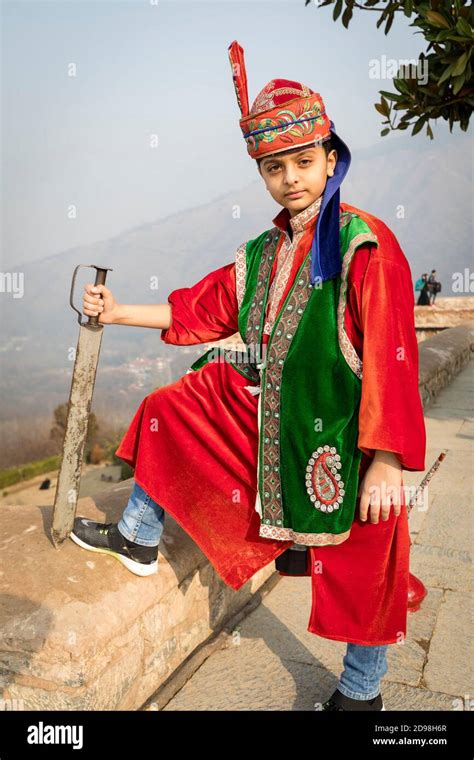 A Young Boy Dressed In Kashmiri Attire And Holding A Sword Stock Photo
