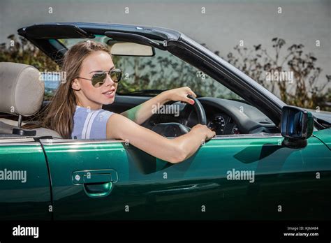 A Beautiful Young Woman Driving Her Convertible Car On A Summer Road