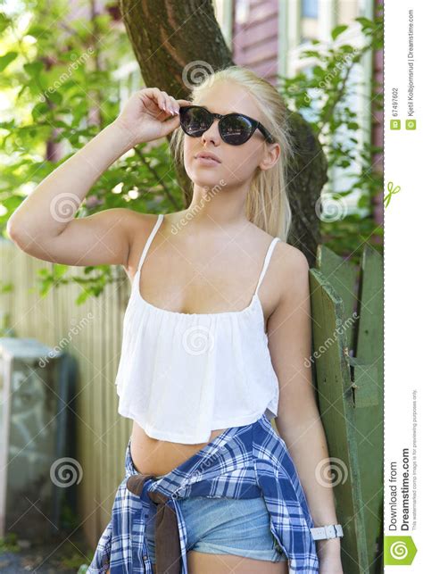 Casual Young Blonde Girl In Front Of Wooden Fence Stock