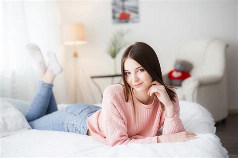 sweater bedroom in bed jeans brunette pink sweater bed smiling women indoors portrait